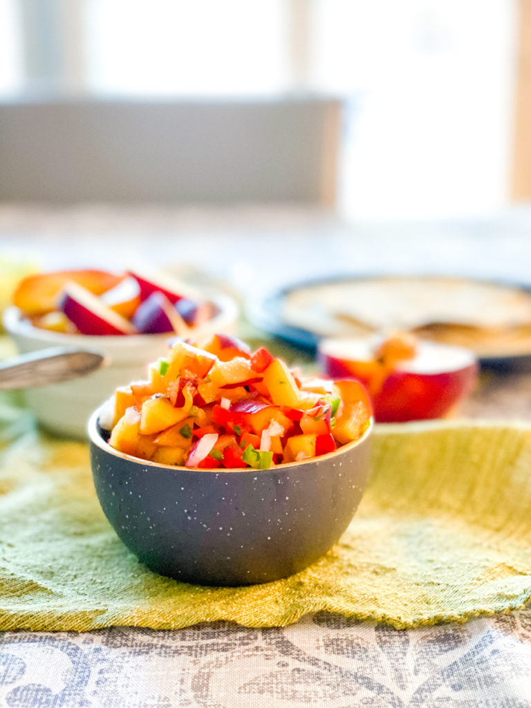 Small grey bowl filled with fresh peach salsa