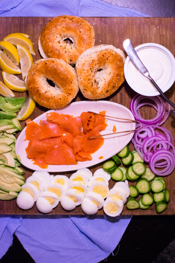 Overhead shot platter with bagels, lox, and accompaniments. 